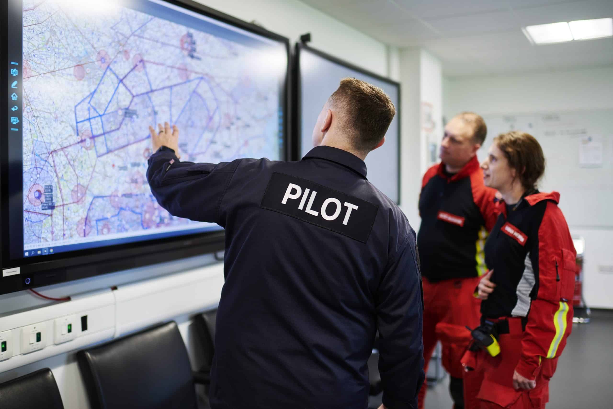 Pilot, Paramedic and Doctor planning out the route for their mission on the map