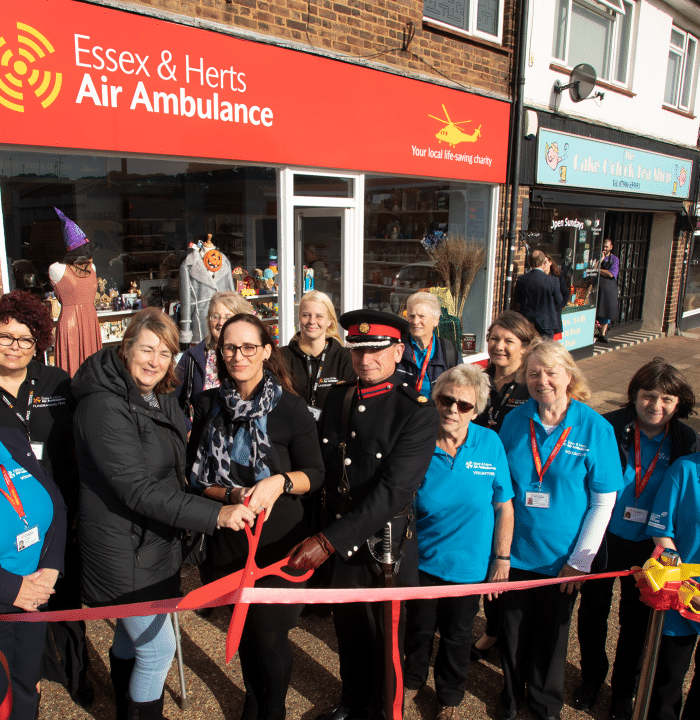 Volunteers and Jane Gurney ribbon cutting for new shop opening